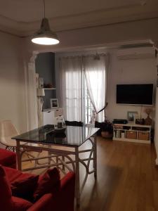 a living room with a table and a television at Apartamento Barrionuevo in Córdoba