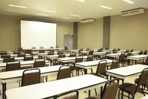 an empty classroom with tables and chairs and a whiteboard at Samba Três Lagoas in Três Lagoas