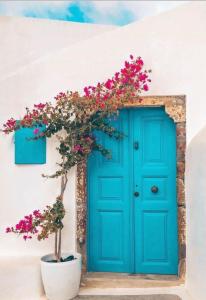 a blue door with flowers in front of a house at Elicriso Villa in Pyrgos