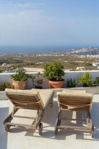 two chairs and a table on a balcony with plants at Elicriso Villa in Pyrgos