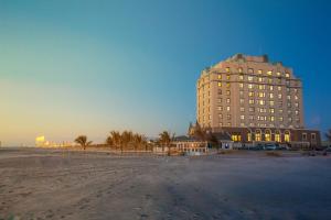 a large building on the beach next to a beach at Legacy Vacation Resorts - Brigantine Beach in Brigantine
