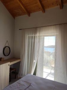 a bedroom with a bed and a window with a view at Olivar del Mar in Nydri
