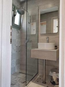uma casa de banho com um lavatório e um chuveiro em Olivar del Mar em Nydri