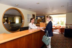 two women shaking hands at a counter in a salon at The Riviera Hotel & Apartments - Alum Chine in Bournemouth