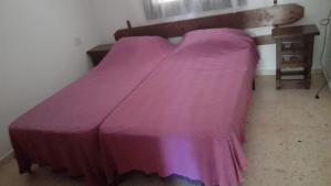 テウラーダにあるSpanien Bungalowの紫の毛布が敷かれたベッド