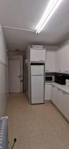 eine Küche mit weißen Schränken und einem Kühlschrank in der Unterkunft Casa Eguino Pet-Friendly in San Sebastián