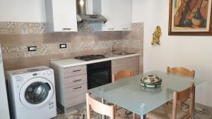 a kitchen with a table and a washing machine at Bingo 1 completo in Alghero