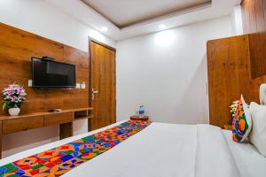 a bedroom with a bed with a colorful blanket on it at Hotel Harmony INN Near Delhi International Airport in New Delhi