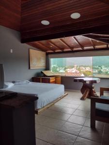 a bedroom with a bed and a large window at Espaço Verano- Master 1 in Niterói