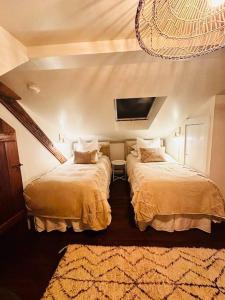 1 dormitorio con 2 camas y TV en la pared en NEW Scandi Ski House! Farmhouse, Hot Tub, en Andover