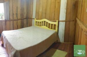 a bedroom with a bed in a wooden room at Refugio Verde Zen in Dois Vizinhos