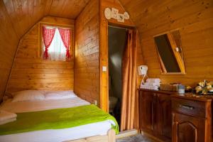 a bedroom with a bed in a wooden cabin at STD SRCE KAMENE GORE in Kamena Gora