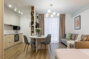 a living room with a couch and a table and chairs at Cozy Garden Studio - Free Parking - Wellness SPA in Sinaia