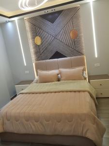 um quarto com uma cama grande e uma grande cabeceira. em الجيزه شارع جامعه الزراعه no Cairo