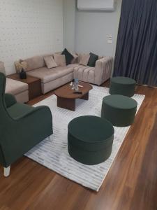 a living room with a couch and two chairs and a table at الجيزه شارع جامعه الزراعه in Cairo