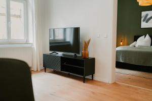 ein Wohnzimmer mit einem Flachbild-TV auf einer Kommode in der Unterkunft Ferienwohnung Elbzauber für 6 l Parkplatz l Balkon in Pirna