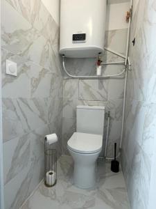 La salle de bains est pourvue de toilettes blanches et d'un lavabo. dans l'établissement Bel appartement vue mer accès direct plage, à Canet