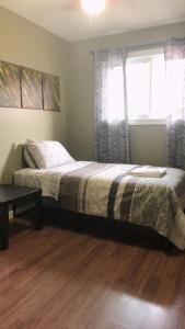 a bedroom with a bed and a window at Private Rooms NAIT Guest House For Men Only in Edmonton