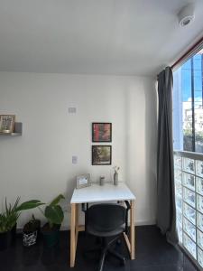 Habitación con ventana y escritorio con silla. en Apartments Belgrano en Buenos Aires