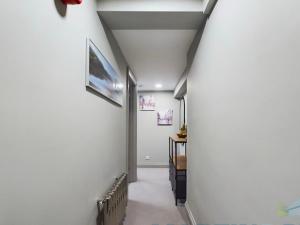 a hallway with white walls and a white column at Spacious open planned 1 bedroom apartment in Burgess Hill