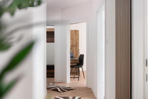 un corridoio con pareti bianche e una sala da pranzo con tavolo di 1-4 Gäste Wohnung W-Lan, Netflix, Amazon, Parken, Arbeitsplatz, 24h Check in ,Vollausgestattet Küche, Handtücher Seife u,v,m für Geschäftsreisende, Paare, Familien , a Datteln