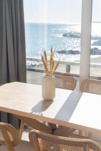 einen Tisch mit einer Vase mit einer Pflanze darauf in der Unterkunft MAR Suites OnlyMalaga in Benalmádena