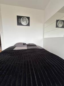 uma cama num quarto com duas fotografias na parede em Studio avec Balcon, belle vue em Courbevoie