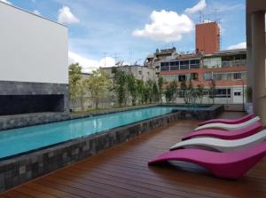 a row of chaise lounges next to a swimming pool at MENSAL Studio Prox Shopping Frei Caneca 103, 105, 203 in Sao Paulo