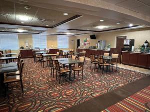 a dining room with tables and chairs on a carpet at Quality Suites Midland North Loop 250 in Midland