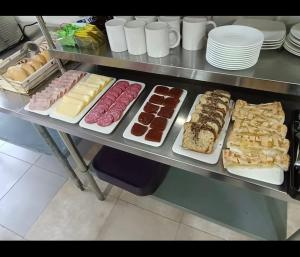 uma linha de buffet com diferentes tipos de alimentos em pratos em Hotel Santa Emilia Salamanca em Salamanca