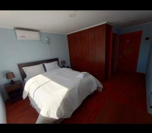 1 dormitorio con cama blanca y suelo de madera en Hotel Santa Emilia Salamanca, en Salamanca