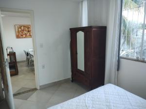 a bedroom with a bed and a wooden cabinet at Sobrado do Méier in Rio de Janeiro