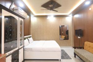 1 dormitorio con 1 cama, TV y sofá en BK home stay, en Transport Nagar