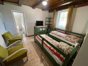 a room with three beds and a desk and chairs at Hídláb Apartman in Kimle