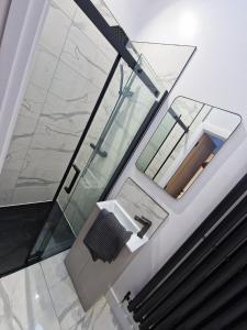 La salle de bains en verre est pourvue d'un lavabo et d'un miroir. dans l'établissement Bryn Glo Cottage, à Capel-Curig