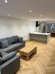 un salon avec un canapé et une cuisine dans l'établissement Bryn Glo Cottage, à Capel-Curig