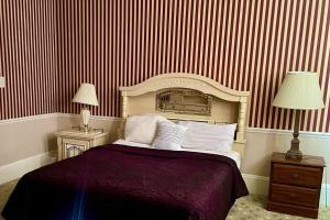 1 dormitorio con 1 cama con rayas rojas y blancas en Best Rooming Houses in Rocky Mount NC. en Rocky Mount