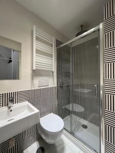 a bathroom with a toilet and a shower and a sink at LOFT 13 in Maiori