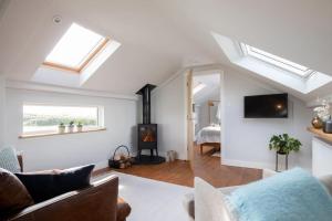 a living room with a couch and a fireplace at Luxury Devon Hayloft with panoramic Dartmoor views in Ilsington