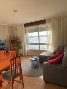 uma sala de estar com um sofá e uma mesa em Piso Vacaciones en el mar em Sanxenxo