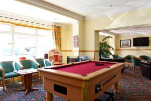 a room with a pool table and chairs at The Riviera Hotel & Apartments - Alum Chine in Bournemouth