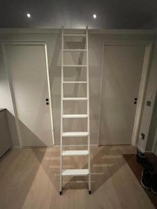 a white ladder in a room with two doors at Eget hus anno 2024 Danderyd, 15min till STHLM city in Danderyd