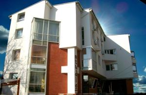 un edificio bianco con mattoni rossi di Pensiunea Studio a Bacău