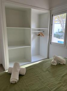 1 dormitorio con 1 cama con toallas en Apartamentos Islanders, en Cala en Forcat