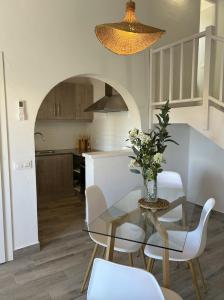 une salle à manger et une cuisine avec une table et des chaises en verre dans l'établissement Apartamentos Islanders, à Cala en Forcat