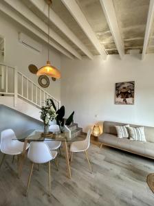 - un salon avec une table, des chaises et un canapé dans l'établissement Apartamentos Islanders, à Cala en Forcat