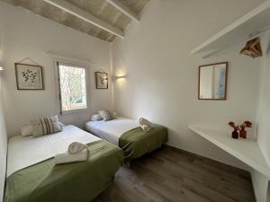 two beds in a room with white walls at Apartamentos Islanders in Cala en Forcat +51 photos