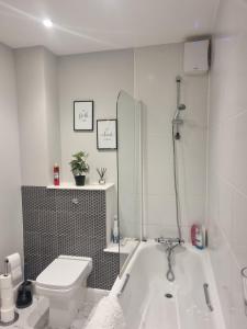 a white bathroom with a tub and a toilet at x2 suites x2 bedroom with free parking & wifi in Croydon