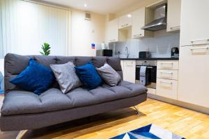 uma sala de estar com um sofá cinzento com almofadas azuis em x2 suites x2 bedroom with free parking & wifi em Croydon