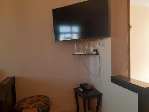 uma televisão de ecrã plano pendurada numa parede com uma mesa em Charmant appartement à louer à meknès em Meknès